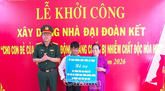  Đại tá Võ Thành Lê, Chính uỷ Bộ Chỉ huy Quân sự tỉnh trao bảng tượng trưng hỗ trợ xây dựng nhà Đại đoàn kết cho con của người tham gia kháng chiến bị nhiễm chất độc hoá học.