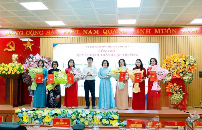 Lãnh đạo phường Kim Liên trao quyết định và tặng hoa chúc mừng 6 cơ sở giáo dục công lập sau sắp xếp. Ảnh: Nguyên Bảo