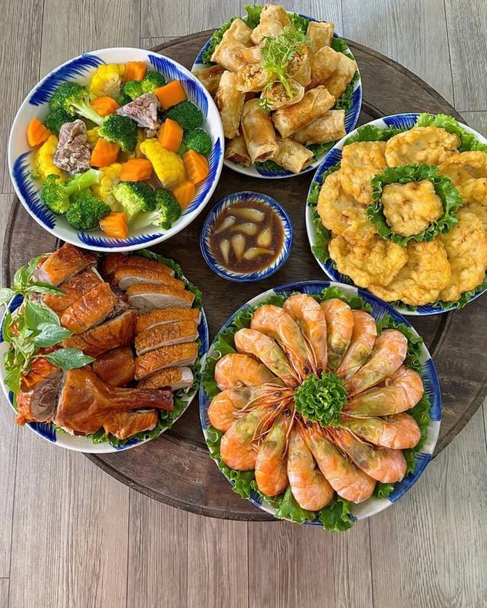 Mâm cơm có sự kết hợp giữa các món hấp, quay, chiên và canh. Tôm hấp giữ vị ngọt tự nhiên, vịt quay đậm đà, nem rán tôm thịt giòn thơm, chả mực dai giòn và bát canh rau củ nấu sườn thanh ngọt. Đây là kiểu mâm cơm thích hợp cho những ngày gia đình có đông người.