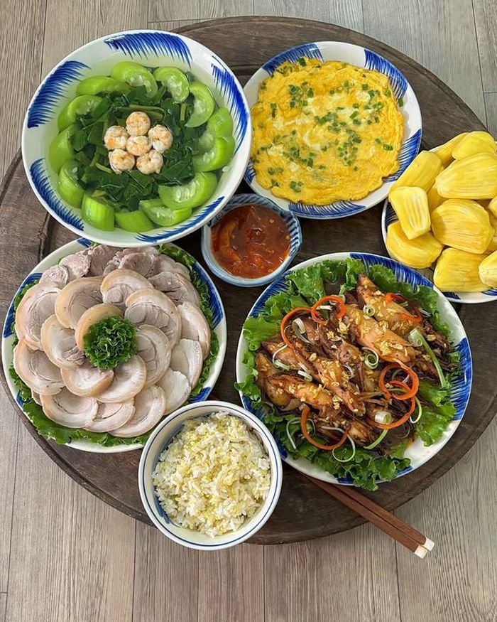 Bắp giò luộc chấm mắm tôm chua, trứng tráng hành vàng ươm, canh mồng tơi nấu tôm ngọt mát và đĩa mít ta thơm lừng cho món tráng miệng. Không cầu kỳ, mâm cơm vẫn có đủ món mặn, món canh và món ăn kèm.