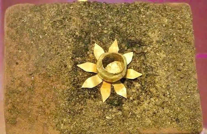 Bình thiêng và hoa sen bằng vàng đặt trên viên gạch ở trung tâm kho thiêng được phát hiện tại di tích An Phú