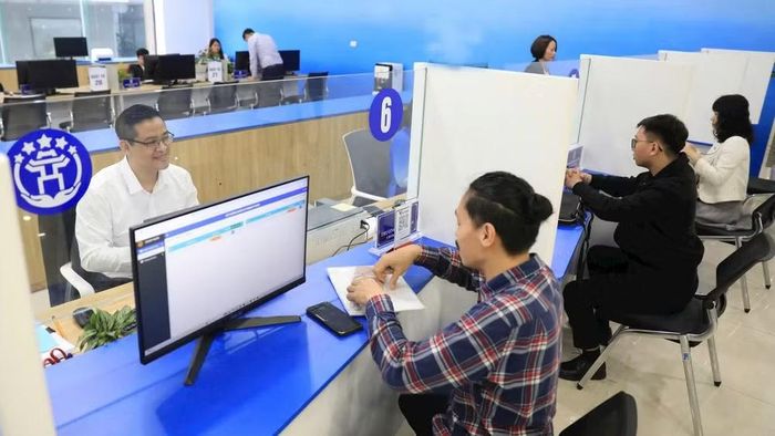 Hỗ trợ người dân giải quyết thủ tục hành chính trực tuyến tại Trung tâm Phục vụ hành chính công chi nhánh Tây Hồ. (Ảnh: QUANG PHONG)