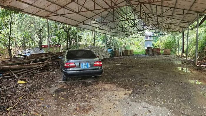 Chiếc ô-tô biển xanh để trong lán của chùa.
