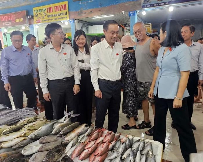 Đoàn giám sát kiểm tra một cửa hàng bán cá ở chợ Xóm Lưới. (Ảnh: Lê Đình Thìn)