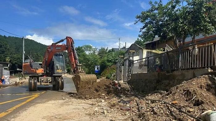 Các đơn vị huy động máy xúc san gạt mặt đường. (Ảnh: MINH ĐỨC)
