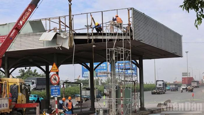 Đơn vị thi công tiến hành tháo dỡ trạm thu phí ngưng hoạt động ở khu vực cầu Đồng Nai trong ngày 11/8. (Ảnh: THIÊN VƯƠNG)