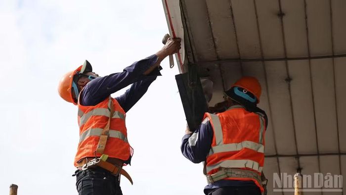 Công nhân tiến hành tháo dỡ trạm thu phí ngưng hoạt động 6 năm qua tại khu vực cầu Đồng Nai. (Ảnh: THIÊN VƯƠNG)