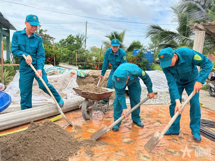 Lực lượng dân quân Ban CHQS xã Hưng Mỹ (Cà Mau) đóng góp ngày công giúp xây dựng nhà cho gia đình con đẻ của người hoạt động kháng chiến bị nhiễm chất độc hóa học.
