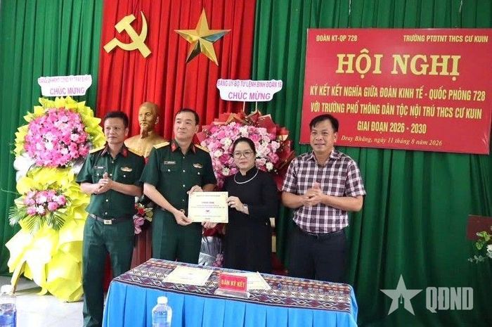  Đại tá Nguyễn Xuân Nguyên và đồng chí Ngô Thị Hương trao đổi văn bản ký kết. 