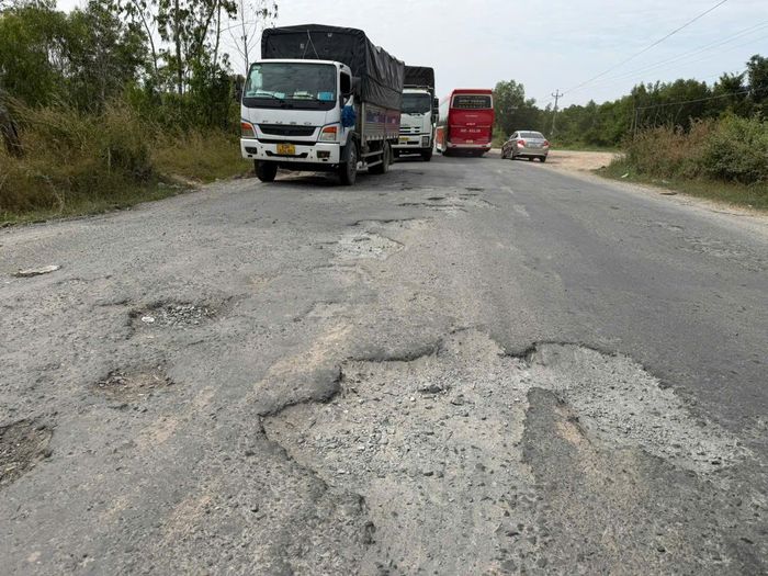 Mặt đường quốc lộ 62 chi chít ổ gà. ẢNH: QUANG VINH