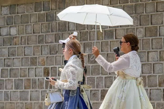  Dù nắng nóng, nhiều du khách nước ngoài vẫn muốn trải nghiệm mặc trang phục hanbok của Hàn Quốc. (Nguồn: Korea Times) 