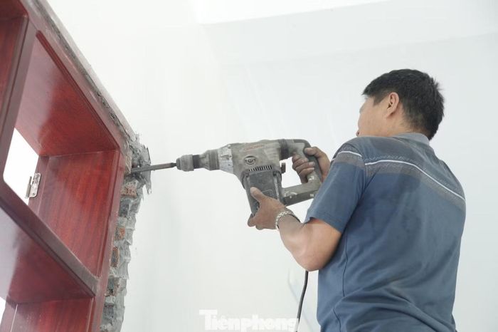 Những người thợ đang tháo dỡ cửa nhà. Ảnh: Nguyễn Thắng.