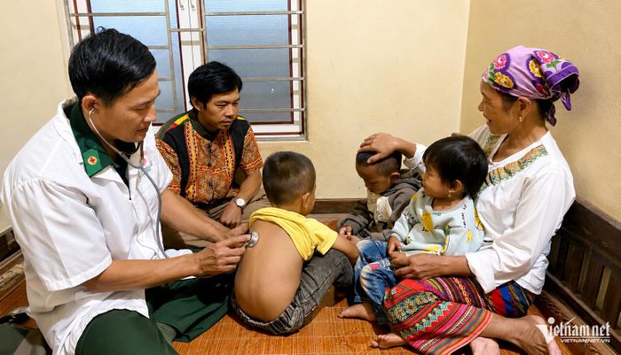 Thiếu tá Nguyễn Đức Long khám bệnh cho trẻ em Chứt ở Rào Tre. Ảnh: Đậu Tình