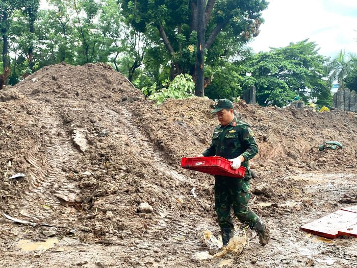 Đội Quy tập hài cốt liệt sĩ vẫn nỗ lực làm nhiệm vụ dù thời tiết TPHCM có mưa lớn. Ảnh: BTL
