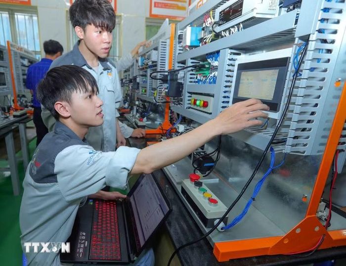 Sinh viên lớp FUNA D đang thực hành môn PLC trong Trung tâm đào tạo sản xuất thông minh HNIVC-FUNA. (Ảnh: Hoàng Hiếu/TTXVN)