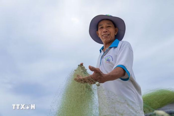 Những tấm lưới được kéo lên bờ, phơi trên bãi cát sau chuyến đi biển đêm của ngư dân Tam Tiến. (Ảnh: Xuân Quý/TTXVN)