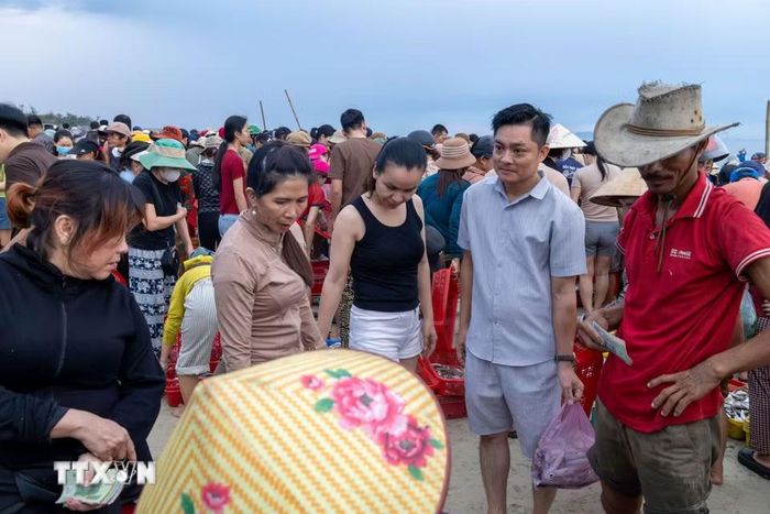 Du khách tìm đến chợ cá Tam Tiến từ sáng sớm để tận mắt chứng kiến cảnh tàu của ngư dân cập bờ, bán hải sản và cảm nhận nhịp sống của một làng chài ven biển. (Ảnh: Xuân Quý/TTXVN)