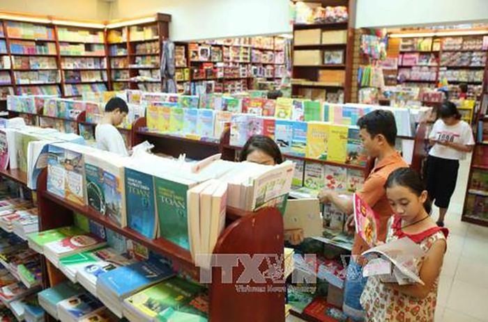 Các em học sinh lựa chọn sách giáo khoa. Ảnh minh họa: TTXVN