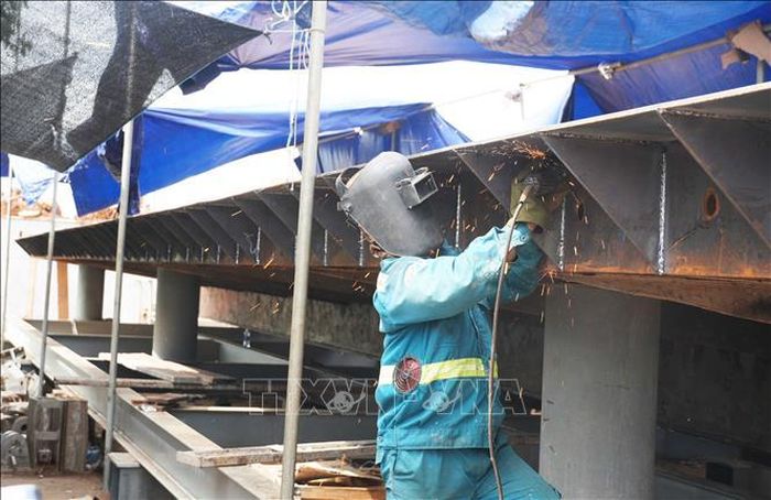 Công nhân sửa chữa cửa van bằng thép của đập Thảo Long trên sông Hương, thành phố Huế.