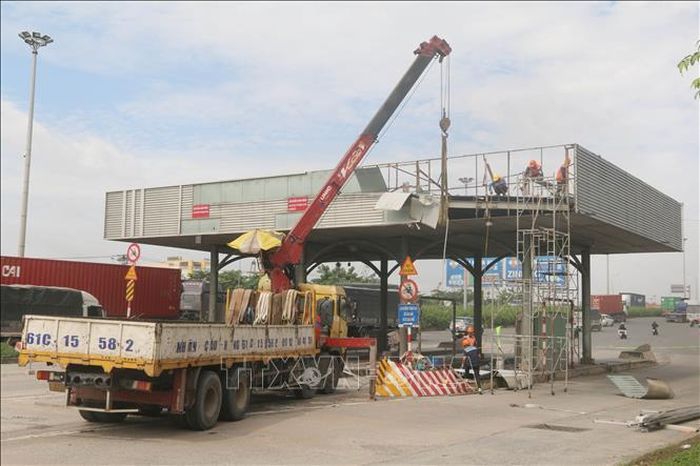 Máy móc, nhân lực thực hiện tháo dỡ trạm thu phí cầu Đồng Nai. Ảnh: Công Phong/TTXVN