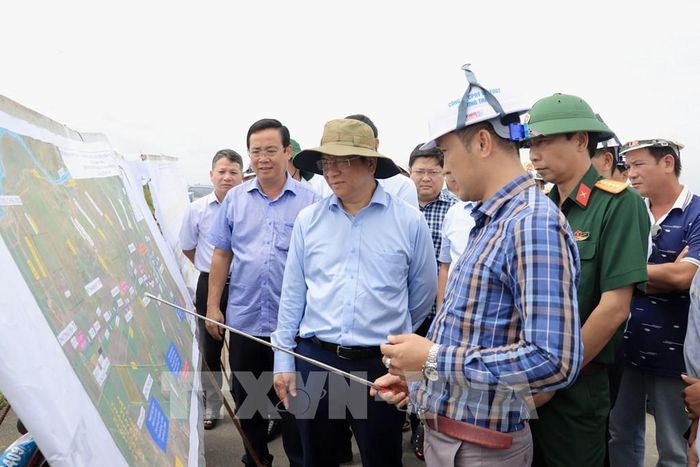 Chủ tịch UBND tỉnh An Giang Hồ Văn Mừng nghe các nhà thầu báo cáo tiến độ thi công tại nút giao Dự án thành phần 1 với Đường tỉnh 943, xã Định Mỹ. Ảnh: Thanh Sang-TTXVN