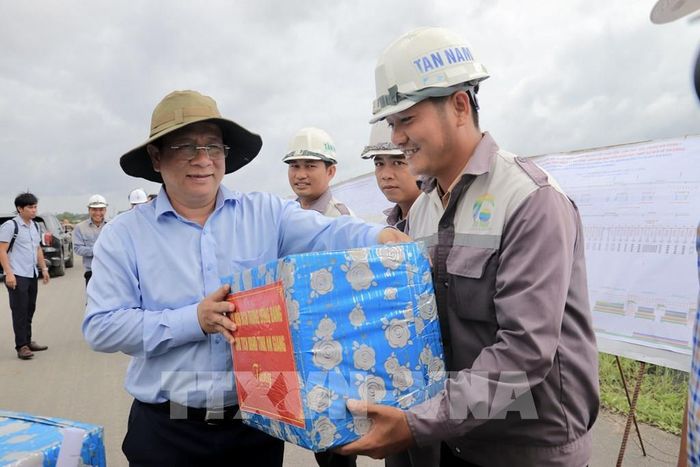 Ông Hồ Văn Mừng, Chủ tịch UBND tỉnh An Giang tặng quà cho các công nhân trên công trường thi công cao tốc tại nút giao với Đường tỉnh 943, xã Định Mỹ. Ảnh: Thanh Sang-TTXVN