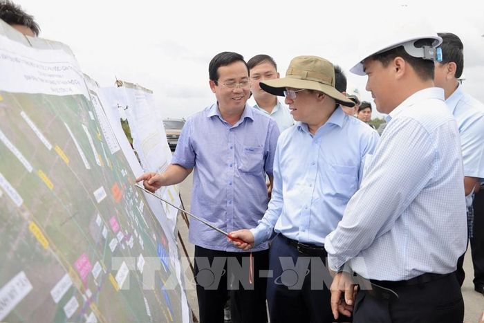 Chủ tịch UBND tỉnh An Giang Hồ Văn Mừng nghe các nhà thầu báo cáo tiến độ thi công tại nút giao Dự án thành phần 1 với Đường tỉnh 943, xã Định Mỹ. Ảnh: Thanh Sang-TTXVN