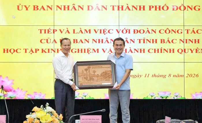  Thay mặt Đoàn công tác, đồng chí Mai Sơn trao quà lưu niệm cho đại diện UBND thành phố Đồng Nai. 