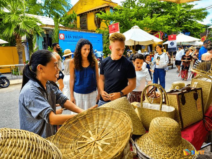 Khách quốc tế tìm hiểu các sản phẩm làm từ vật liệu xanh của người dân địa phương trưng bày tại lễ hội. Ảnh: QUỐC TUẤN
