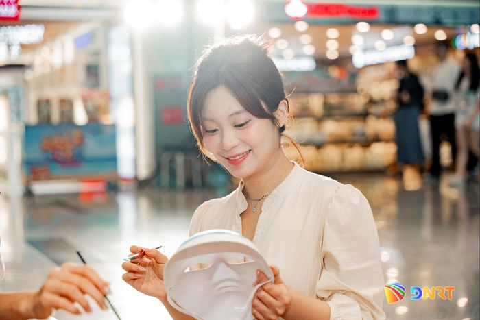 Du khách trải nghiệm vẽ mặt nạ tuồng. Ảnh: AHT