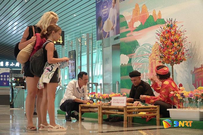 Du khách trải nghiệm workshop gấp hoa giấy Thanh Tiên tại Nhà ga T2 Cảng hàng không quốc tế Đà Nẵng. Ảnh: LÂM VIÊN - KHÔI NGUYÊN