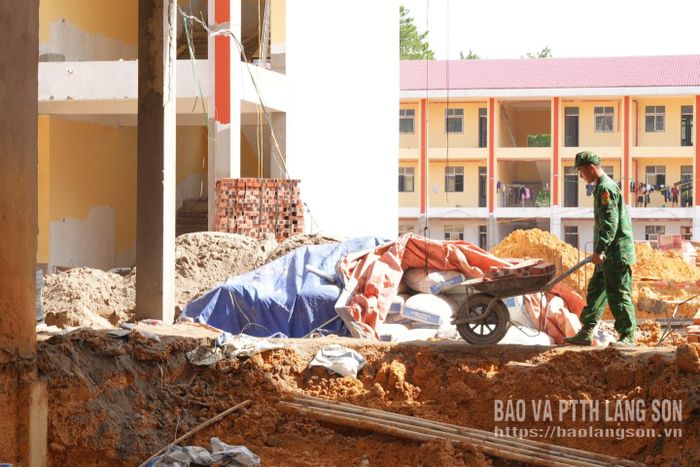 Trên công trường, không có khoảng cách giữa quân và dân. Lực lượng biên phòng phối hợp cùng Nhân dân địa phương dùng xe đẩy cơ động vật liệu qua các khu vực sụt lún, đảm bảo tiến độ thi công không bị gián đoạn.