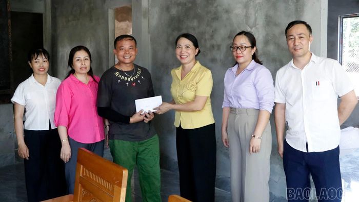 Đồng chí Lê Thị Lụa - Chủ tịch Ủy ban MTTQ Việt Nam xã và lãnh đạo địa phương trao kinh phí hỗ trợ làm nhà cho gia đình anh Đào Văn Thức, thôn Hợp Thành.