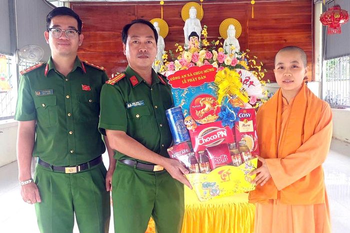 Trung tá Nông Xuân Thảo - Phó Trưởng Công an xã Sông Lũy (đứng giữa) chúc mừng dịp Lễ Phật đản