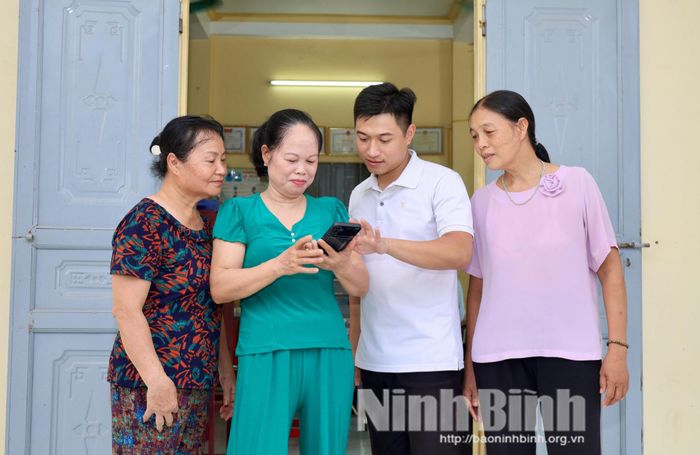Anh Đặng Quang Giang, Tổ trưởng Tổ dân phố Cao Đài, phường Mỹ Lộc hướng dẫn người dân cài ứng dụng trên điện thoại.
