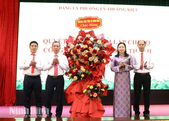 Đồng chí Đinh Thị Lụa, Phó Bí thư Tỉnh ủy, Chủ tịch Ủy ban MTTQ Việt Nam tỉnh tặng hoa chúc mừng Chi bộ Công ty cổ phần xi măng Long Thành.