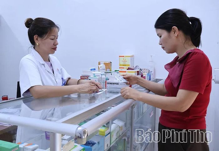 Nhân viên Trạm y tế xã Tam Dương Bắc cấp thuốc bảo hiểm y tế cho người bệnh.