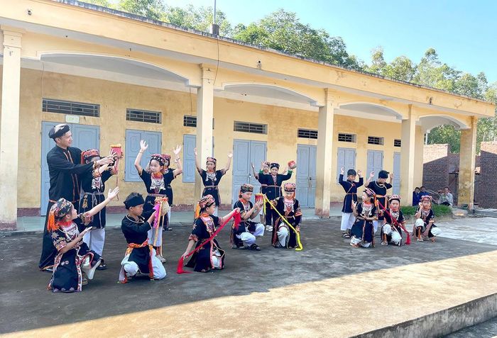 Thầy giáo Nguyễn Đình Kỷ hướng dẫn các em trong Câu lạc bộ giữ gìn bản sắc văn hóa dân tộc Dao của trường tập múa.