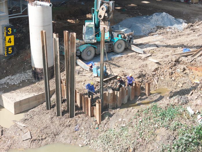 Tại khu vực cầu Kênh Mương, nhiều công nhân cùng máy móc, thiết bị được huy động thi công, đẩy nhanh tiến độ dự án.