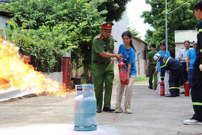Báo cáo viên Nguyễn Tuấn Đức, cán bộ Đội Chữa cháy và Cứu nạn, cứu hộ khu vực số 1, hướng dẫn các em thực hành dập lửa.
