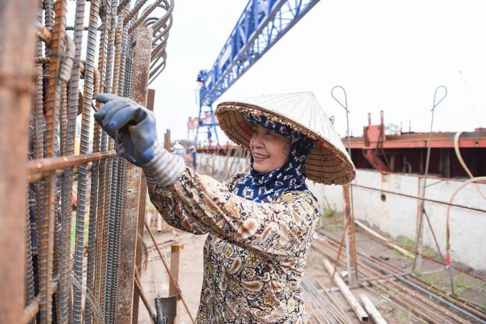 Tại mũi thi công cầu vượt sông Hồng, nhiều công nhân và thiết bị máy móc đã được nhà thầu huy động làm việc trên công trường.