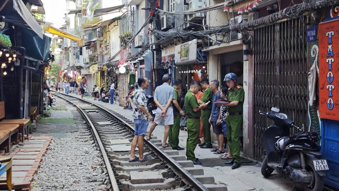 Lực lượng chức năng làm việc với người dân xung quanh khu vực đường tàu. Ảnh: NXH