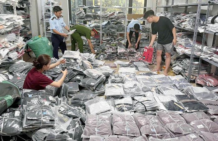 Lực lượng chức năng kiểm tra sản phẩm giả mạo nhãn hiệu nổi tiếng tại cơ sở kinh doanh quần áo ở Khu công nghiệp Ninh Hiệp (xã Phù Đổng). Ảnh: Hoài Nam