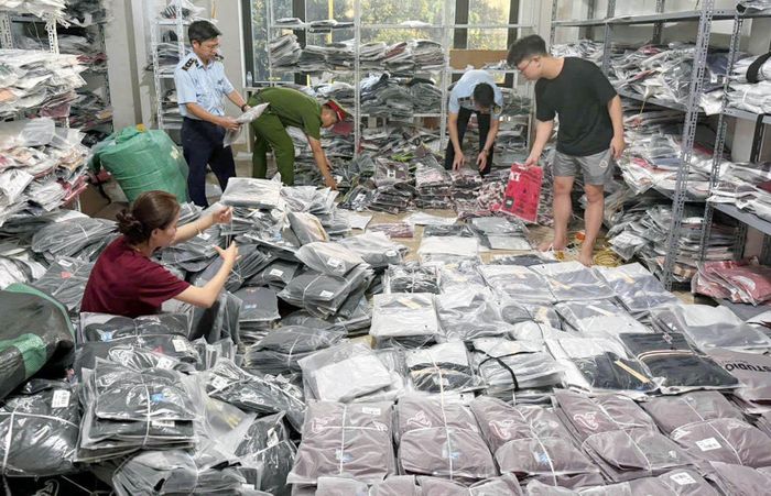 Lực lượng chức năng kiểm tra sản phẩm giả mạo nhãn hiệu nổi tiếng tại cơ sở kinh doanh quần áo ở Khu công nghiệp Ninh Hiệp (xã Phù Đổng). Ảnh: Hoài Nam