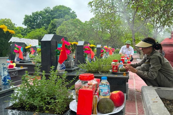 Cán bộ, nhân viên phục vụ tại Nghĩa trang Mai Dịch cẩn trọng, tỉ mỉ sắp lễ trên từng ngôi mộ liệt sĩ chưa xác định danh tính, chuẩn bị cho thời khắc thực hiện nghi thức tâm linh, triển khai nhiệm vụ lấy mẫu sinh phẩm phục vụ giám định ADN. Ảnh: Mai Hoa