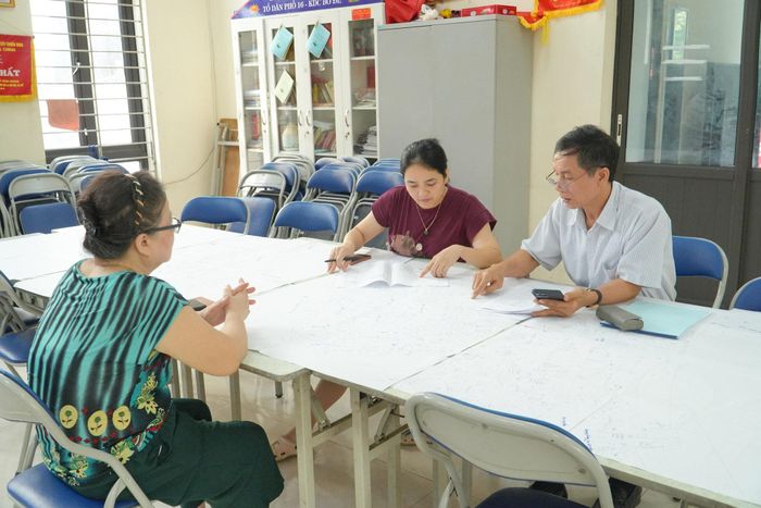 Ông Nguyễn Phi Đức, Tổ trưởng Tổ dân phố 22, trao đổi với người dân trong quá trình rà soát, cập nhật dữ liệu đất đai. Ảnh: Tùng Lâm.