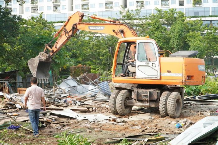 Máy xúc tiến hành phá dỡ các công trình vi phạm. PV