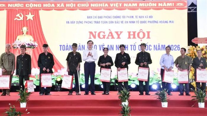 Đồng chí Đoàn Minh Huấn và đoàn công tác Trung ương tặng quà các gia đình khó khăn trên địa bàn phường Hoàng Mai. (Ảnh: PT)