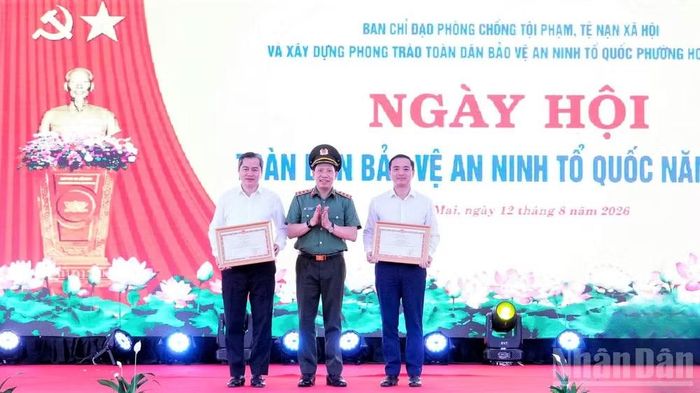 Thượng tướng Lê Văn Tuyến, Ủy viên Trung ương Đảng, Thứ trưởng Công an trao Bằng khen của Bộ trưởng Công an cho nhân dân, cán bộ phường Vinh Phú và Bí thư Đảng ủy phường Hoàng Mai. (Ảnh: PT)