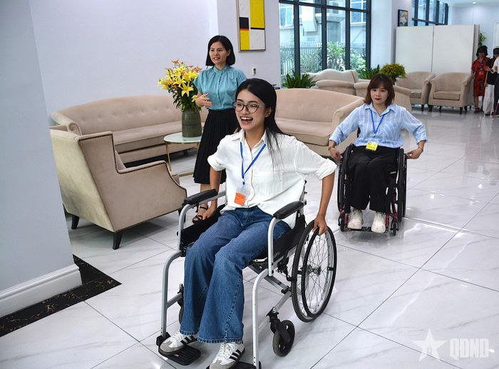 Bạn Nguyễn Thùy Dương (áo trắng), sinh viên Học viện Báo chí và Tuyên truyền trải nghiệm ngồi xe lăn. 